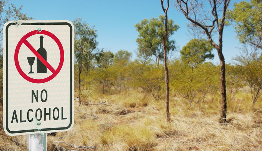 A no alcohol sign in the foreground with native bush land in the background